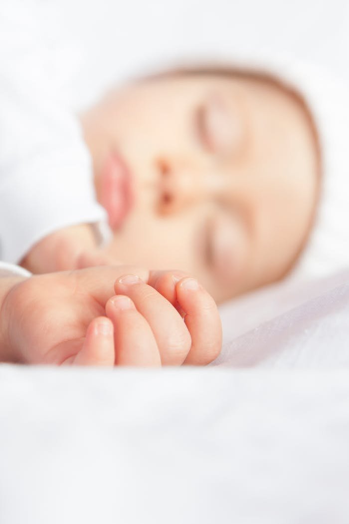 A serene and innocent close-up of a sleeping newborn baby with soft focus.